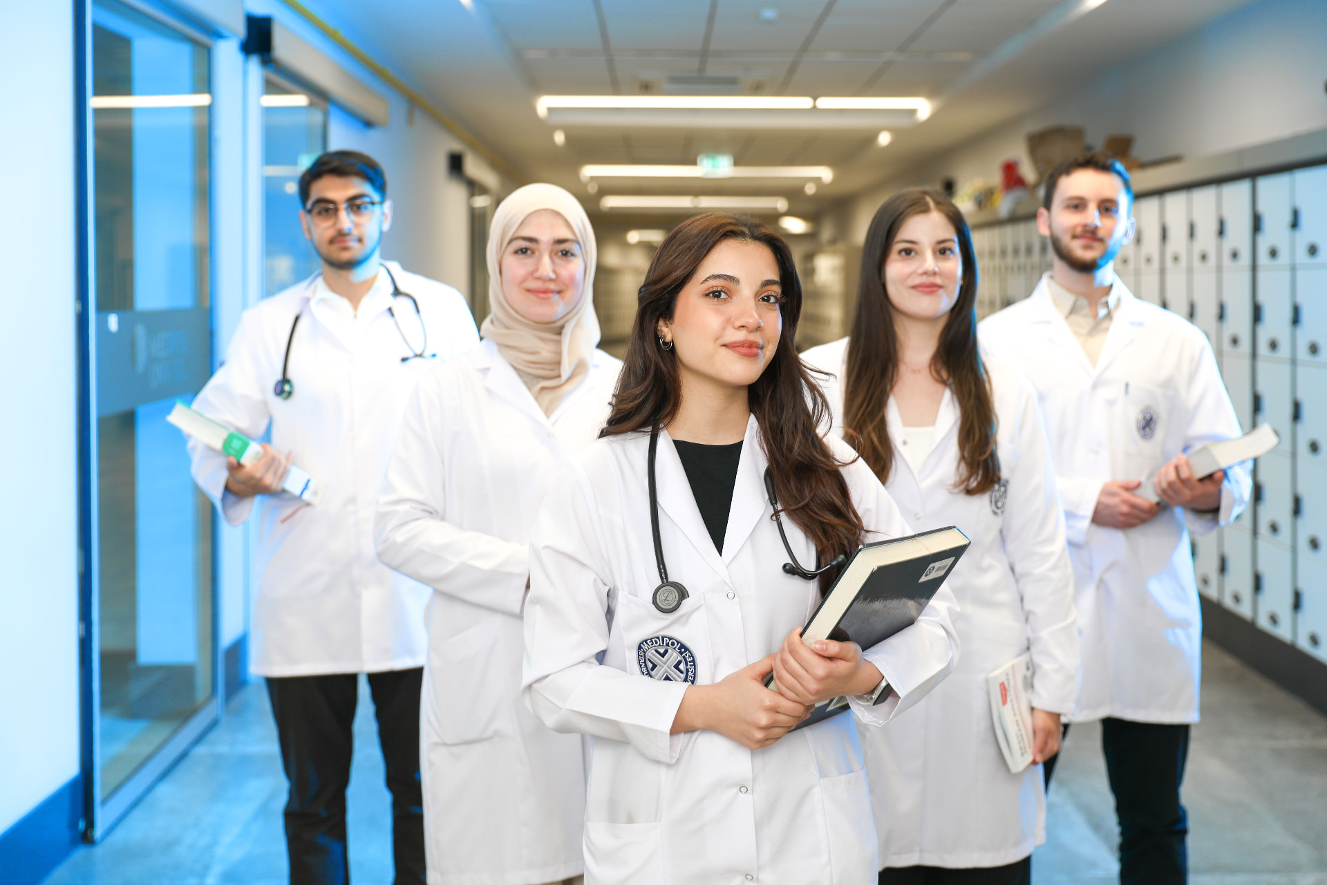 Group of medical students in white coats standing in a university hallway